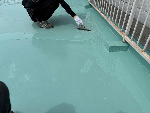 床面をヘラで均す作業